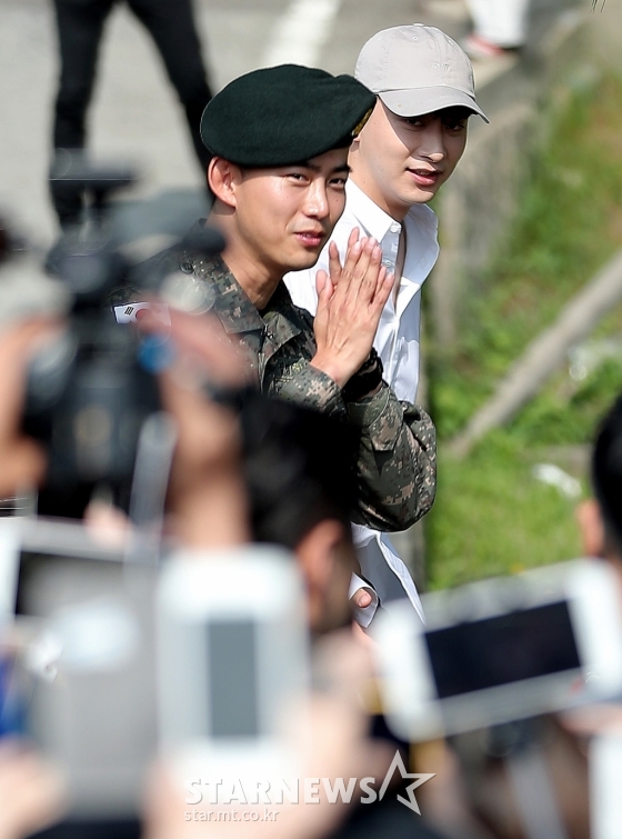 아이돌그룹 2PM 멤버 겸 배우 옥택연이 16일 오전 경기도 고양시 일산동구 백마회관에서 진행된 전역식에서 마중 나온 황찬성과 팬들에게 인사하고 있다. /고양(경기)=김창현 기자