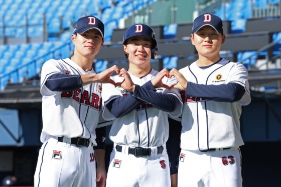 김택연(오른쪽)이 동기 전다민(왼쪽), 여동건과 두산 유니폼을 입고 합동 하트 포즈를 취하고 있다. /사진=두산 베어스