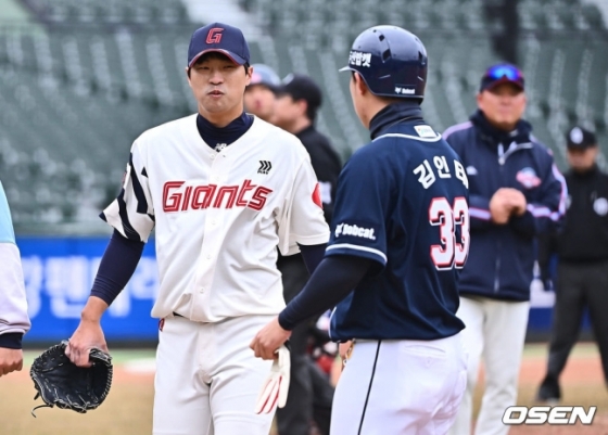 롯데 구승민(왼쪽)이 11일 사직 두산전에서 타구에 맞은 후 두산 김인태에게 미소를 지어보이고 있다. 