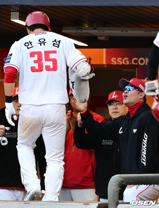 한유섬(왼쪽)이 투런 홈런 뒤 더그아웃으로 들어가며 이숭용 감독(오른쪽)의 축하를 받고 있다.