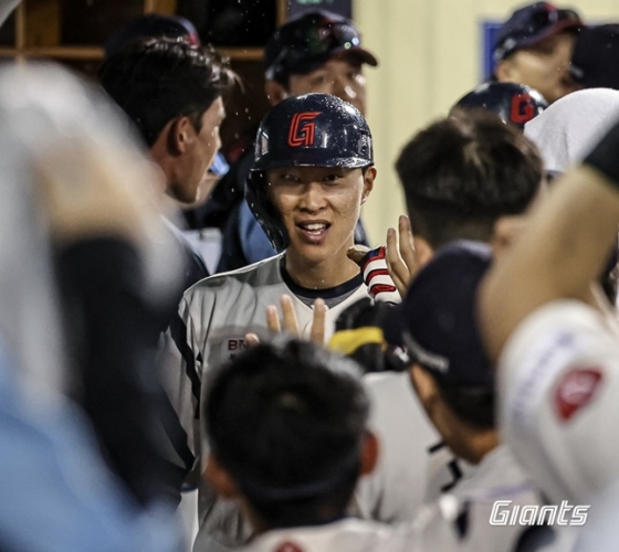 롯데 박승욱이 16일 울산 두산전에서 7회 말 최항의 적시타 때 득점한 후 동료들의 축하를 받고 있다. /사진=롯데 자이언츠 제공 