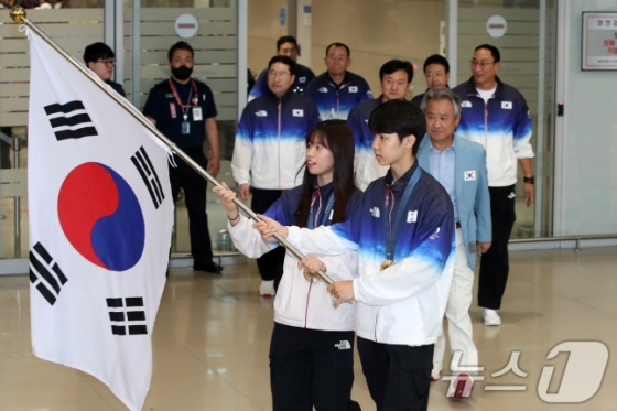 태극기를 든 복싱 국가대표 임애지(왼쪽)와 태권도 국가대표 박태준(오른쪽)이 13일 인천국제공항을 통해 귀국하고 있다. /사진=뉴스1