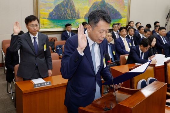 김광일 MBK파트너스 부회장(오른쪽)과 강동수 SK이노베이션 부사장이 서울 여의도 국회 정무위원회에서 열린 금융감독원·서민금융진흥원 국정감사에서 증인 선서를 하고 있는 모습. 사진제공=뉴스1  