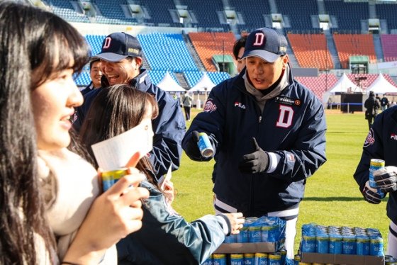 이승엽 감독(오른쪽)이 직접 마련한 따뜻한 캔커피를 경기장에 입장하는 팬들에게 나눠주고 있다. /사진=두산 베어스 제공