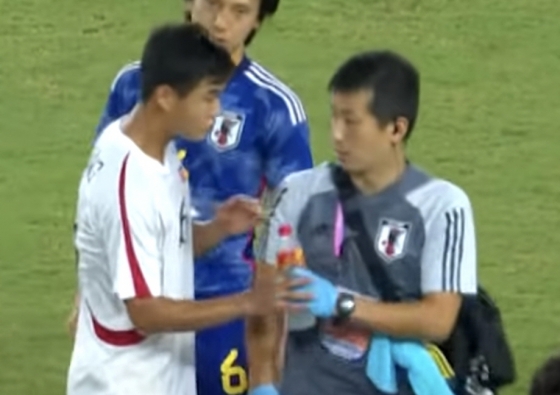 북한 축구대표팀 김유성이 일본 스태프에게 다가가 물병을 빼앗고 있다. /사진=SNS 영상 갈무리