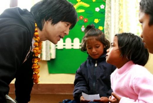 최수종과 신이가 선물한 난로에 옹기종기 모여앉아 스케치북에 꿈 그려보는 시간. 사진의 최수종 친선대사가 아동에게 꿈을 묻고 있다.<사진제공=굿네이버스><br /><br />
