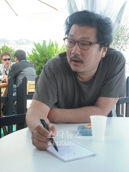 ⓒ17일 칸의 영진위 부스에서 홍상수 감독이 '해변의 여인'의 한 장면처럼 도형을 그려가며 자신의 영화관을 설명하고 있다.