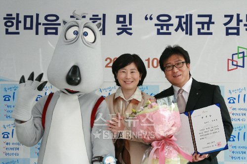 ↑한국인터넷진흥원이 6일 가락동 KISA 신청사에서 영화 '해운대'를 만든 윤제균 감독을 '118 홍보대사'로 위촉했다. 김희정 원장(가운데)이 윤제균 감독(오른쪽)에게 118 홍보대사 위촉장을 수여한 뒤 기념촬영을 하고 있다.<br /><br />
<br /><br />
