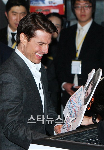 2009년 내한한 할리우드 스타 톰 크루즈가 팬들로부터 딸 수리 인형을 선물 받고 환하게 웃고 있다. 이명근 기자