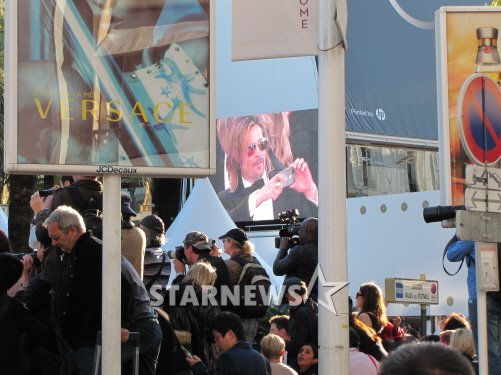 22일 프랑스 칸 레드카펫에 오른 브래드 피트가 환호하는 관객들의 모습을 사진에 담는 장면이 전광판으로 중계되고 있다. 칸(프랑스)=전형화 기자