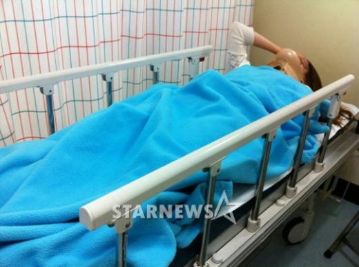 교통사고 직후 목 보호대를 한 채 병원에 누워 있는 소연 ⓒ스타뉴스
