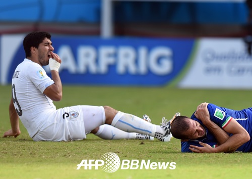 브라질 월드컵 이탈리아전에서 키엘리니를 깨문 뒤 쓰러져 고통을 호소하는 수아레즈(좌). /AFPBBNews=뉴스1