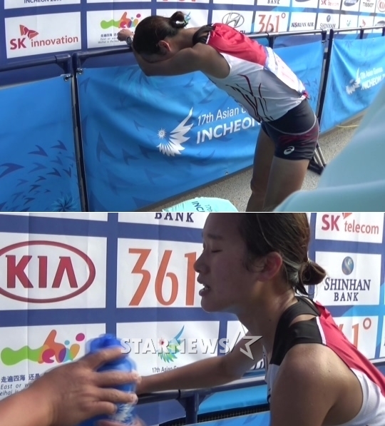 한국의 여자 마라토너 김성은이 42.195km를 완주한 뒤 믹스트존에서 힘겹게 물을 마시려 하고 있다.