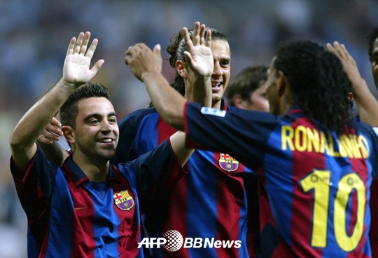 2004년 바르셀로나에서 활약하던 호나우지뉴(오른쪽)와 하이파이브를 나누는 사비(왼쪽)의 모습. /AFPBBNews=뉴스1
