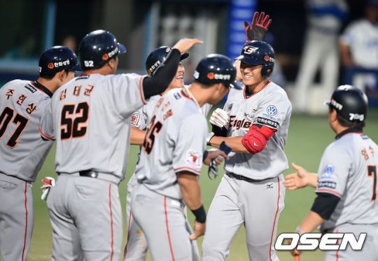 신성현(오른쪽에서 두 번째)이 만루포를 때려낸 뒤 홈에서 동료들의 축하 인사를 받고 있다. /사진=OSEN<br /><br />
<br /><br />
