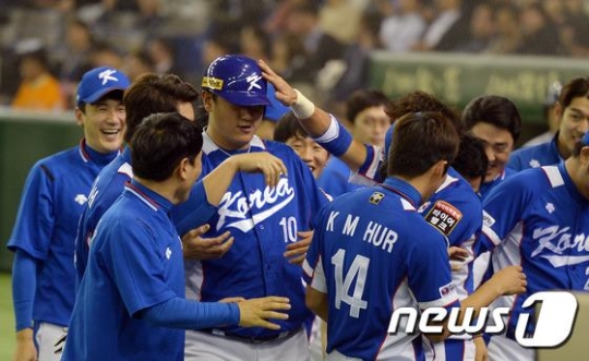 19일 오후 일본 도쿄돔에서 열린 2015 WBSC 프리미어12 4강전 대한민국과 일본의 경기가 4대 3 한국의 승리로 끝나며 결승행을 확정지었다. 이대호가 9회초 무사 만루 역전 적시타를 친 뒤 교체되며 덕아웃에서 동료 선수들과 기쁨을 나누고 있다. /사진=뉴스1<br /><br />
<br /><br />
