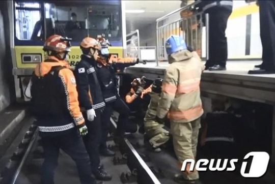분당선 구룡역에서 119 대원들이 지하철 선로에 떨어져 부상 당한 시민을 구조하고 있다./사진=뉴스1<br /><br />
<br /><br />
