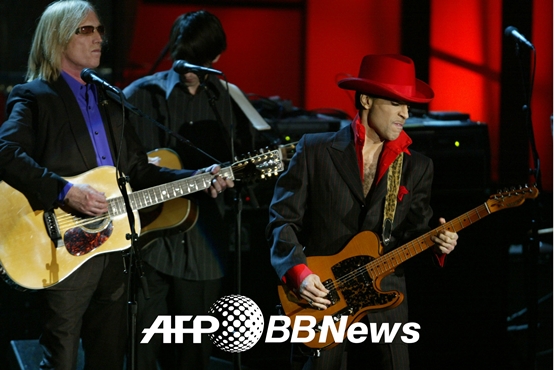 2004년 3월 미국 뉴욕시티에서 열린 제 19회 로큰롤 명예의 전당 헌액 기념식에서 자신과 함께 로큰롤 명예의 전당에 이름을 올린 비틀즈 멤버 조지 해리슨의 노래를 연주하고 있는 프린스(오른쪽)의 모습 /AFPBBNews=뉴스1