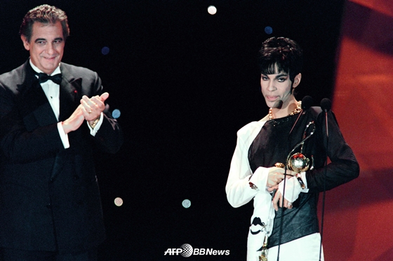 1994년 5월 모나코에서 열린 월드 뮤직 어워드에서 이탈리아 테너 플라시도 도밍고(왼쪽)으로부터 \'팝 인더스트리 공로상\'을 전해받은 뒤 수상소감을 밝히고 있는 프린스 /AFPBBNews=뉴스1
