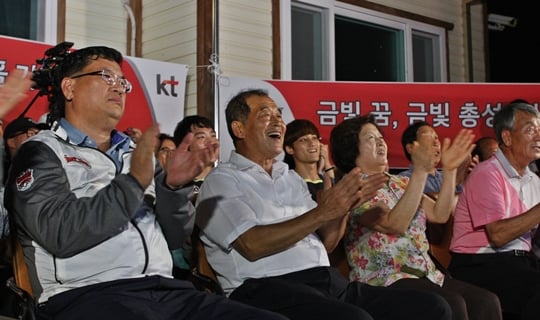 진종오의 본가에서 아버지 진재호 씨와 어머니 박숙자 씨(65)가 KT사격단 임종택 단장, KT사격선수단, 가족 및 지역 주민들과 함께 응원하는 모습. /사진=kt스포츠 제공<br /><br />
<br /><br />
