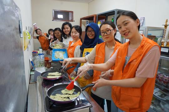 한화생명 해피프렌즈 청소년 봉사단이 인도네시아 수라바야 지역의 청소년 창업 아카데미에 참가해 인도네시아 튀김과자를 함께 만들고 있다. /사진=한화생명