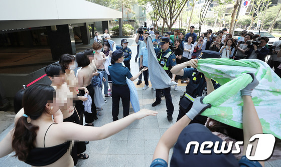 불꽃페미액션 활동가들이 지난 2일 오후 서울 강남구 페이스북코리아 사옥 앞에서 성차별적 규정에 맞서는 상의탈의 퍼포먼스를 벌이다 경찰에게 제지 당하고 있다./사진=뉴스1