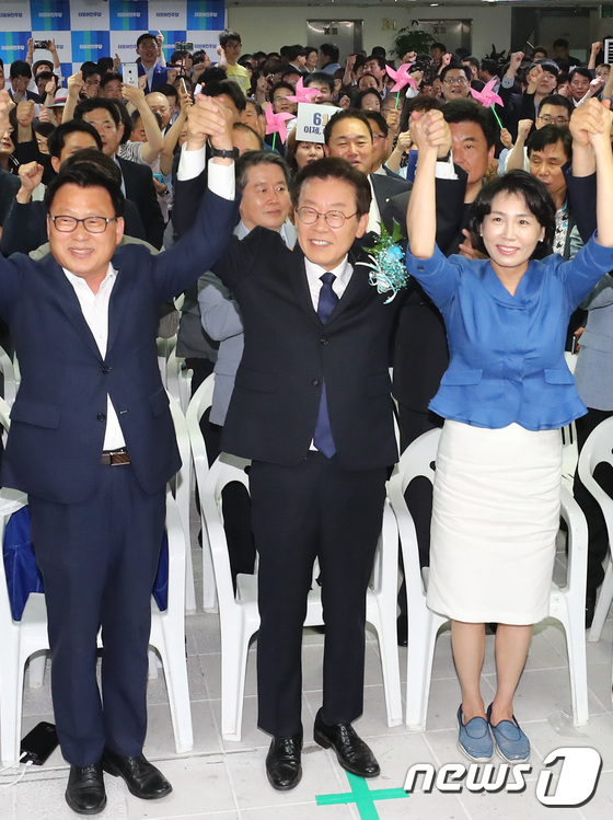 이재명 더불어민주당 경기도지사 후보와 부인 김혜경 씨를 비롯한 참석자들이 6.13 지방선거 투표일인 13일 출구조사 발표를 시청하며 만세를 하고 있다./사진=뉴스1