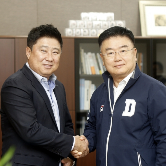 김태형 감독이 재계약 도장을 찍은 후 두산 베어스 김태룡 단장(오른쪽)과 악수를 나누고 있다. /사진=두산 베어스 제공