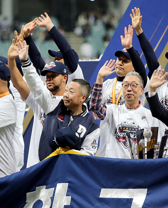 박정원 두산 그룹 회장(왼쪽)과 박지원 두산 그룹 부회장(오른쪽)이 손을 들며 두산 팬들에게 인사를 건네고 있다. /사진=두산 베어스 제공