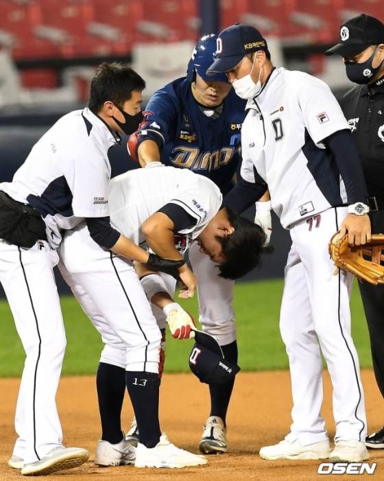 강습 타구에 오른쪽 손목을 강타당한 허경민(가운데)이 고통스러워 하고 있다.