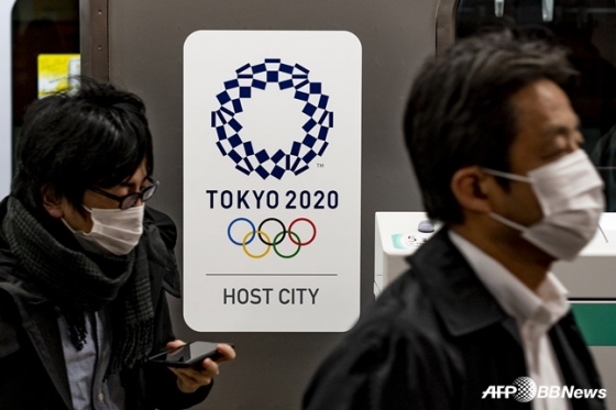 도쿄올림픽 포스터 옆을 마스크를 쓴 시민들이 지나가고 있다. /AFPBBNews=뉴스1