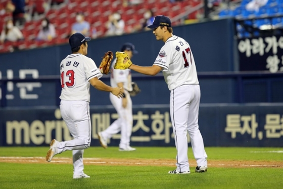 허경민과 글러브 하이파이브를 나누고 있는 홍건희(오른쪽). /사진=두산 베어스 제공