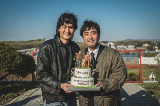 류승룡과 박해준이 영화 '정가네 목장' 크랭크업 축하 케이크를 들고 포즈를 취하고 있다. 