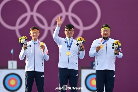 한국 남자 양궁 대표팀의 김제덕(왼쪽부터)-김우진-오진혁이 단체전 금메달을 목에 건 채 인사하고 있다. /AFPBBNews=뉴스1