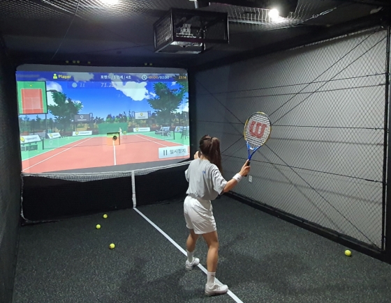 실내 테니스장을 방문한 고객이 스크린테니스를 즐기고 있다.