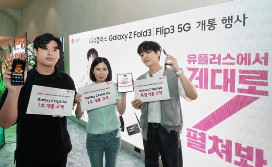 지난 23일 서울 강남역에 위치한 복합문화공간 일상비일상의틈에서 열린 '갤럭시 Z Fold3·Flip3 1호 개통 행사'에 참석한 가수 사이먼 도미닉(오른쪽)이 1호 개통고객들과 기념촬영 하는 모습.