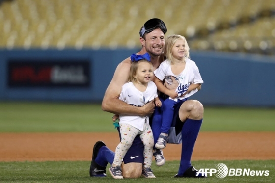 LA 다저스 투수 맥스 슈어저(가운데)가 지난 7일(한국시간) 세인트루이스와 와일드카드 경기에서 승리한 후 두 딸과 함께 기념 촬영을 하고 있다.  /AFPBBNews=뉴스1