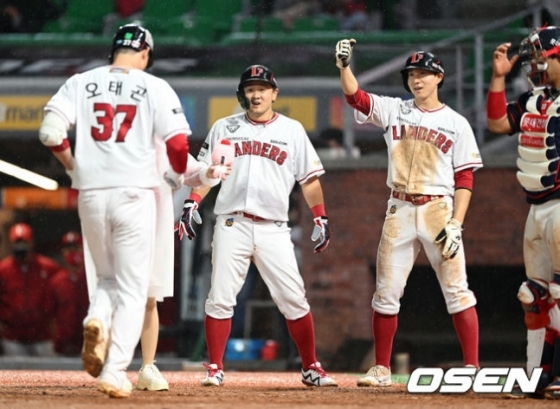 25일 인천 롯데전 5회말 2사 1,2루에서 SSG 오태곤이 좌월 스리런 홈런을 치고 홈에서 최주환(가운데)과 박성한(오른쪽)의 축하를 받고 있다.