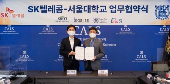 서울대학교 농업생명과학대학에서 장홍성 SKT 광고·데이터 CO담당(오른쪽)과 류영렬 서울대학교 조경지역시스템공학부 교수가 &#039;스마트시티 글로벌 인재양성을 위한 업무협약&#039;을 체결식에서 기념사진을 촬영하고 있다.