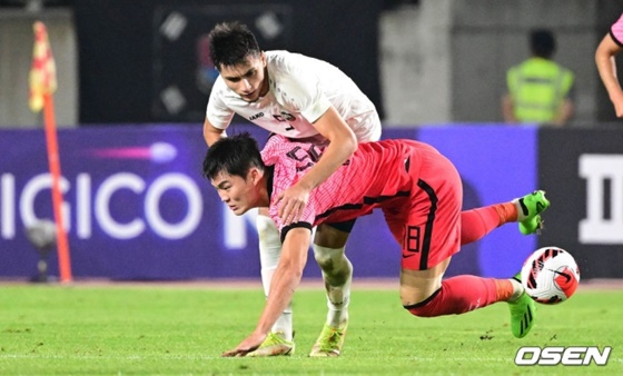 한국 올림픽 축구대표팀 공격수 오현규(빨간색 유니폼)가 우즈베키슽안의 거친 수비에 넘어지고 있다. /사진=OSEN