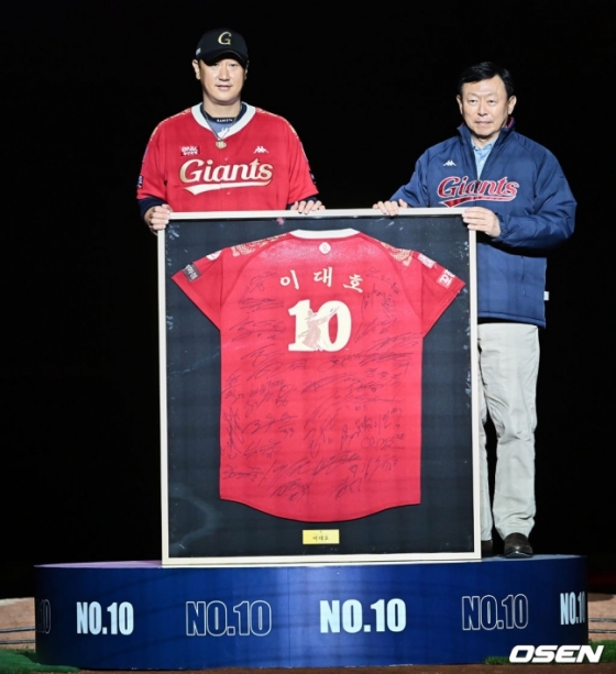 이대호(왼쪽)가 영구결번식에서 신동빈 롯데그룹 회장에게 사인 유니폼을 선물하고 있다. 