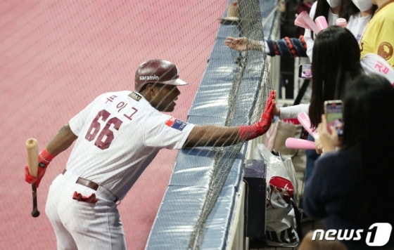 푸이그(왼쪽)가 10월 28일 서울 구로구 고척스카이돔에서 열린 LG 트윈스와 플레이오프 4차전에서 3회말 솔로 홈런을 친 뒤 어린이 팬과 하이파이브를 나누고 있다. /사진=뉴스1