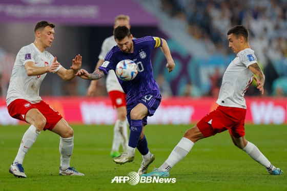 아르헨티나 리오넬 메시(오른쪽)가 1일 폴란드와의 2022 FIFA 카타르 월드컵 조별리그 최종전 폴란드전에서 수비수들 사이로 드리블 돌파를 하고 있다. /AFPBBNews=뉴스1