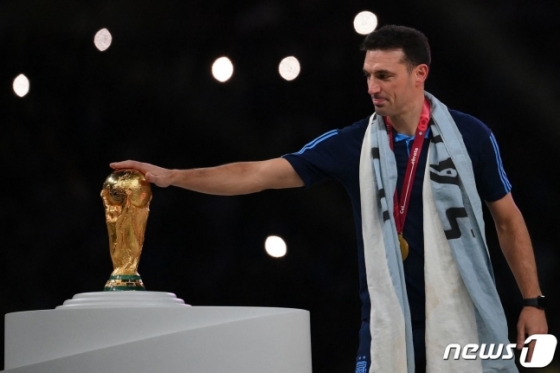 19일(한국시간) 월드컵 우승 트로피를 만지는 리오넬 스칼로니 아르헨티나 감독.  /사진=뉴스1