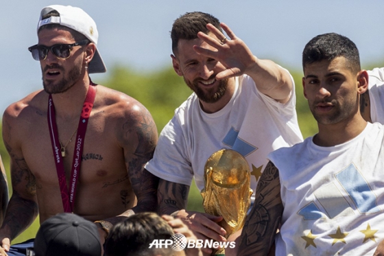 아르헨티나를 36년 만에 우승으로 이끈 뒤 귀국한 리오넬 메시(가운데)가 월드컵 우승 트로피를 손에 쥐고 팬들에게 인사하고 있다. /AFPBBNews=뉴스1