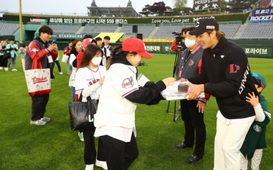 김광현(오른쪽)이 팬들에게 150승 기념 굿즈를 선물하고 있다./사진=SSG 랜더스