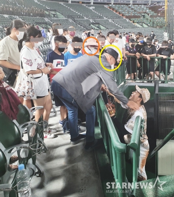 키움 김휘집(사진 오른쪽 아래)이 지난해 6월 부산 사직야구장에서 롯데전이 끝난 후 3루 관중석을 찾아 외할머니(주황색 원)와 외할아버지(노란색 원)와 인사를 나누고 있다./사진=김동윤 기자