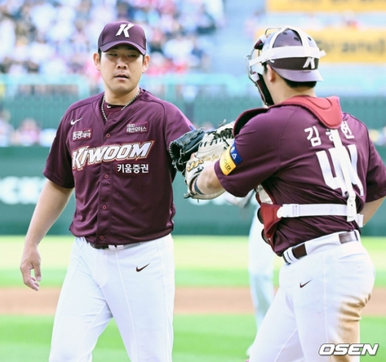 키움 정찬헌(왼쪽)이 3일 인천 SSG전에서 김동헌에게 공을 건네받고 있다.