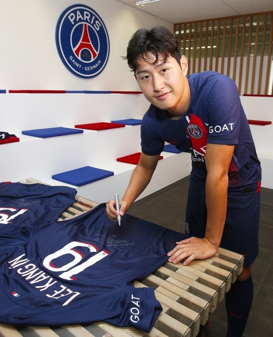 PSG 유니폼에 사인하는 이강인. /사진=PSG SNS