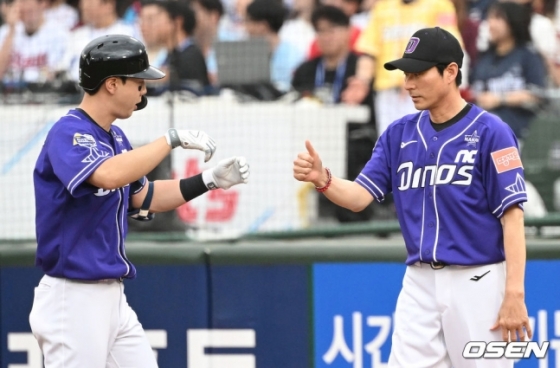 나눔 올스타 박건우(NC)가 15일 부산 사직야구장에서 열린 2023 KBO 올스타전에서 1회말 안타를 치고 나간 뒤 강인권(NC) 1루 코치에게 90도 고개를 숙이며 장비를 전달하고 있다.